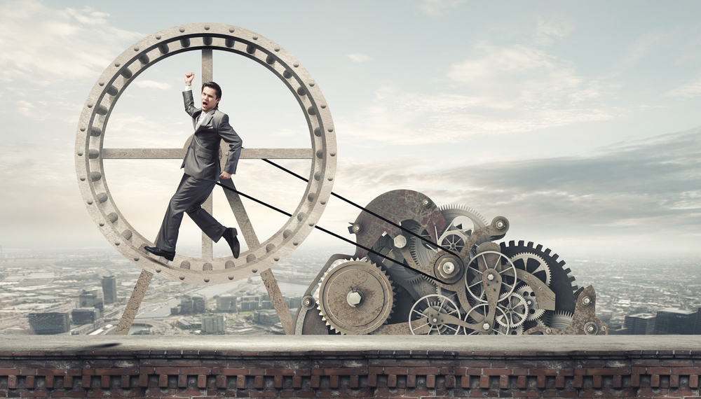 Young businessman in suit running in hamster wheel